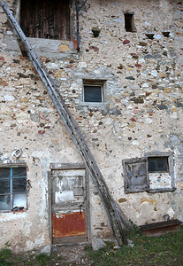 斜木梯靠在旧马厩的墙上图片