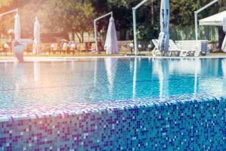 带木甲板的游泳池在酒店夏日阳光明媚的日子休闲椅游泳池中的沙滩日光浴床邀背景图片