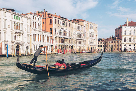 威尼斯船夫将贡多拉平底船穿过意大利威尼斯的大运河贡多拉是一种传统的平底威尼斯划艇这是意大利威尼斯的背景图片