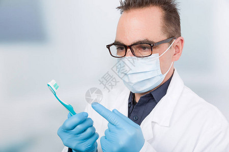 有医用手套的牙医展示牙刷图片