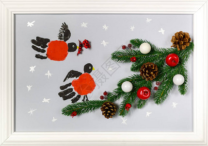 手掌的印花被程式化为红腹灰雀枞树分支与锥体红苹果和白球框架中的手工制作图片作为新年或圣背景图片