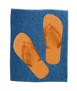 蓝色地毯上一对橙色拖鞋白图片