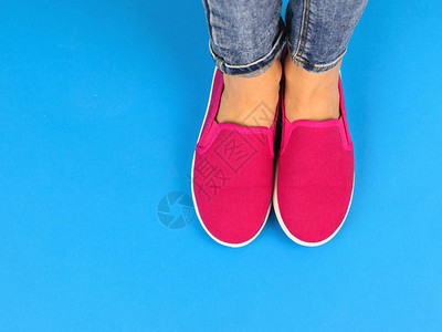穿着红色运动鞋的女孩的腿在蓝地板上背景图片