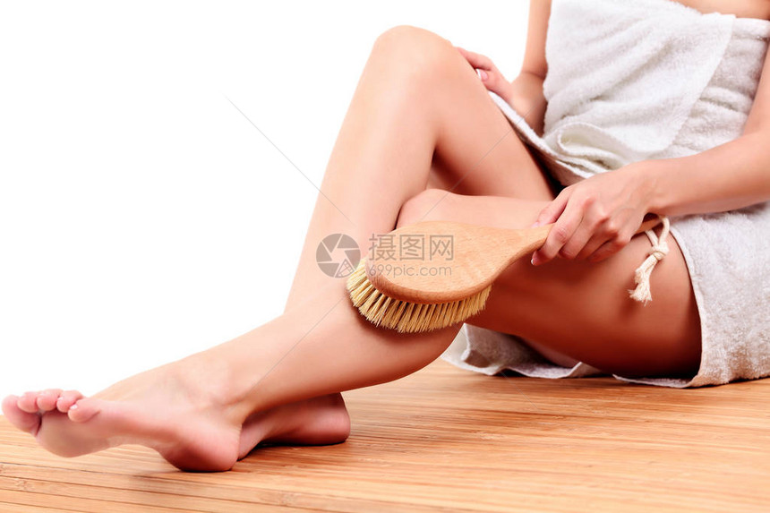 妇女用大刷子在腿上按摩皮肤孤立图片