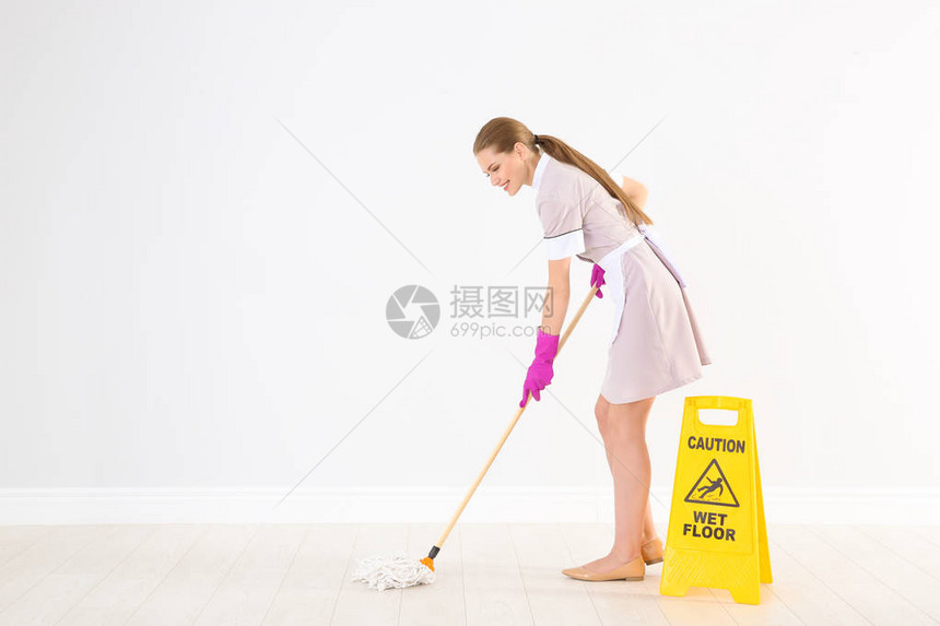 在WETFLOOR附近带拖把的年轻女保图片