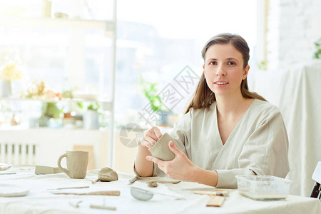 创意女在制作杯子和其他手工用品的同时图片