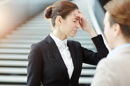 令人焦虑的女商人摸头部图片