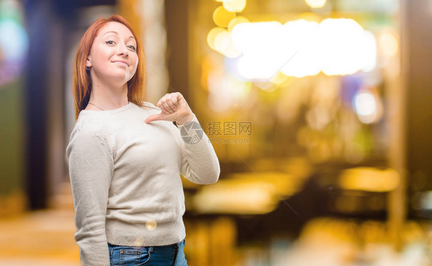 美丽的年轻红发美女骄傲兴奋和傲慢指着夜图片