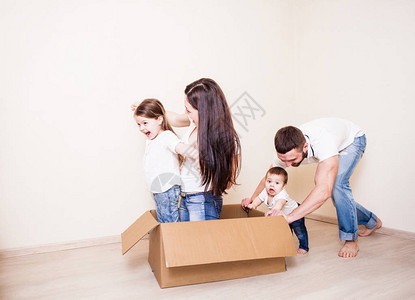 四个人的家庭在房间里玩纸盒游戏一图片