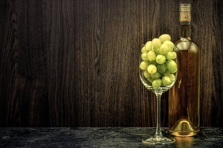 装满葡萄的酒瓶和玻璃杯背景图片