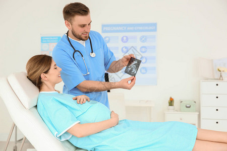 妇科咨询在诊所向孕妇显示超声图片