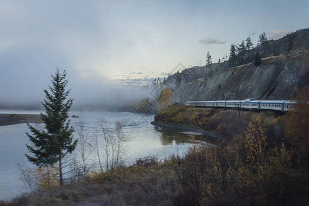 秋晨山河边的火车图片