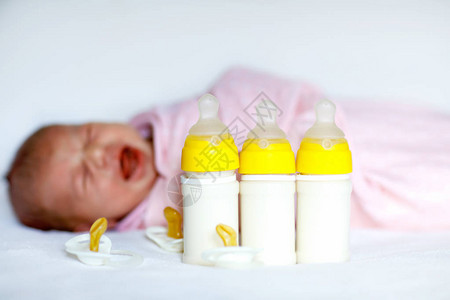 带着奶瓶哭泣的新生女婴儿配方奶粉新出生的孩子图片
