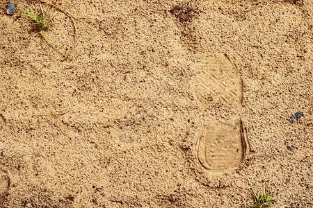 湿沙上的鞋印沿着海滩走图片