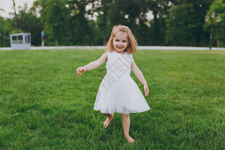 微笑的小可爱小女孩穿着轻便的衣服走路和跑步图片