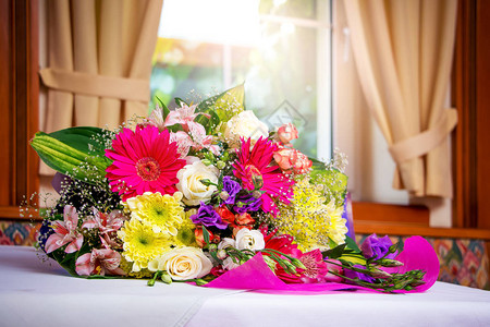 餐厅靠窗的桌子上放着一束华丽的鲜花生日祝福的鲜花节日花束鲜图片