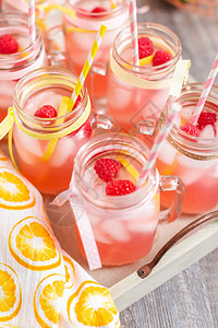 用新鲜柠檬和覆盆子装饰的覆盆子柠檬水装在玻璃瓶里图片