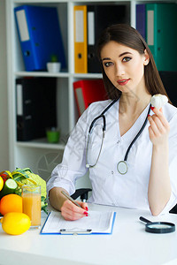 健康营养师医生手里拿着大蒜健康的营养新鲜蔬菜和水果在桌子上光室图片