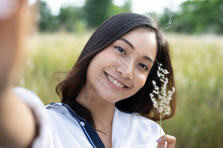 亚裔女在草地和草地的放松时间欢笑微图片