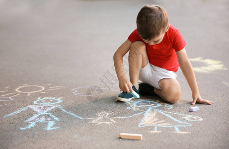 小孩子用粉笔在沥青上画家庭图片