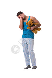 穿着睡衣带着玩具动物的青年男子在白色背景图片