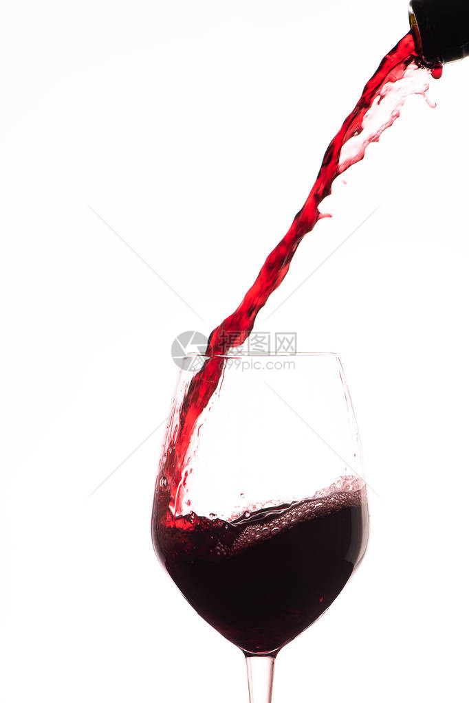 红酒倒在酒杯里在白色背景上图片