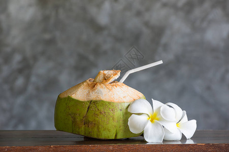 深色背景下木桌上的椰子健背景图片