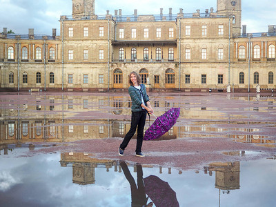 一个女人背着包和雨伞在古宫背景的美丽历史之地Gatchi图片