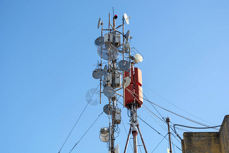 建筑物屋顶上有许多无线电信和卫星天线基站室外设备的平板天线光纤光图片