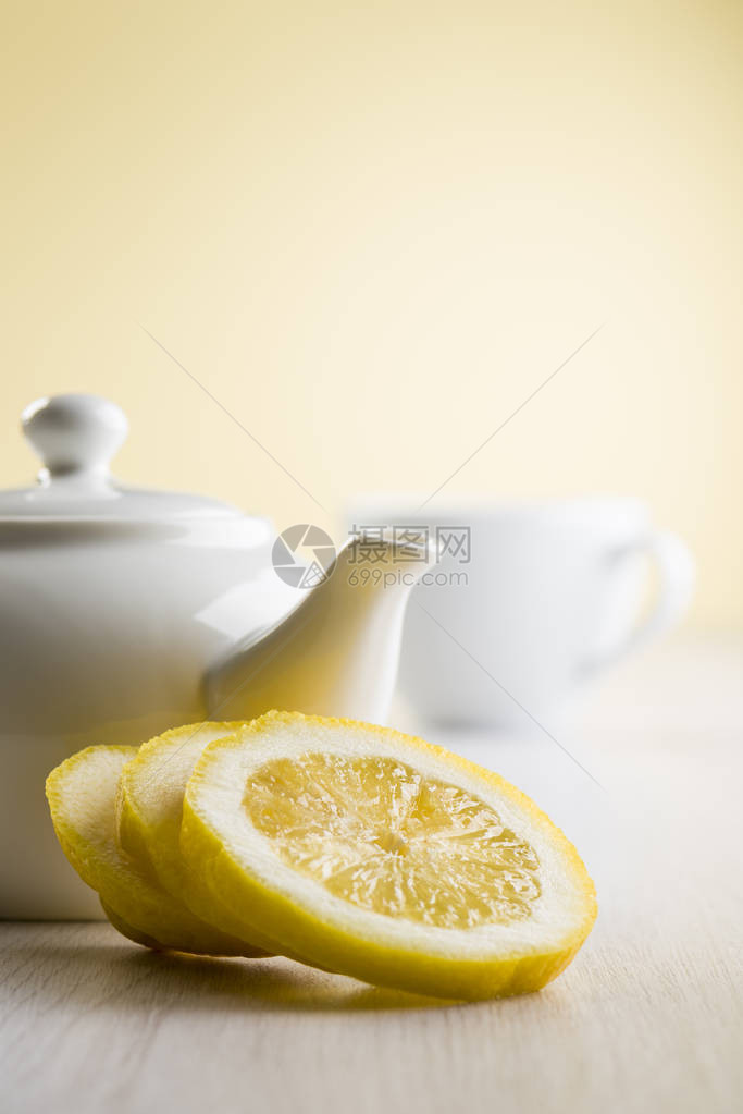 桌上有茶壶和杯子的柠檬片图片