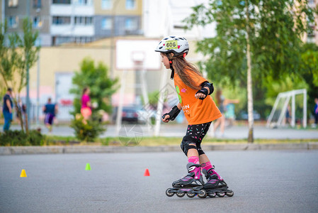 漂亮的少女轮滑在柏油乡村道路上的轮滑鞋上背景图片