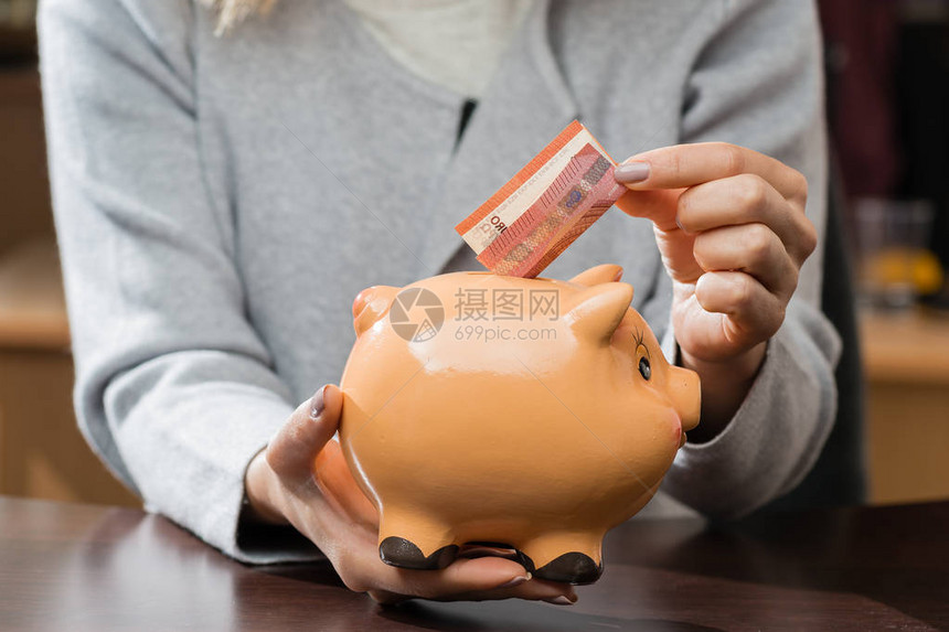 女人把名片放在一个有趣的存钱罐里未来商业储蓄经济图片