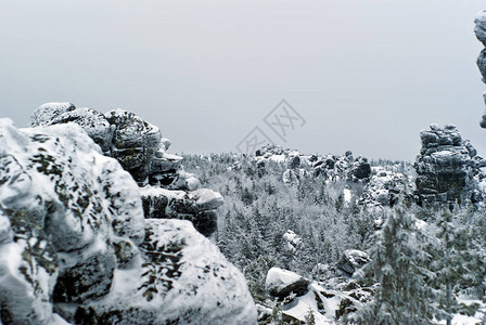 高地原冬季森林中巨大的冰冻石崖景观背景图片