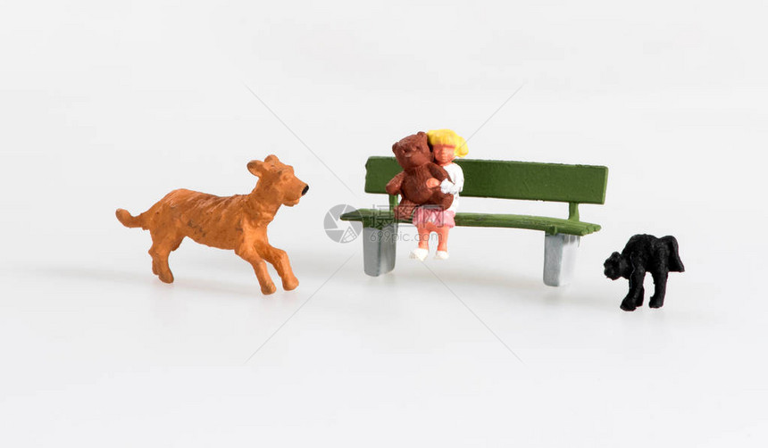 坐在一个生锈的长椅上带着宠物狗和猫抱着泰迪熊抱图片