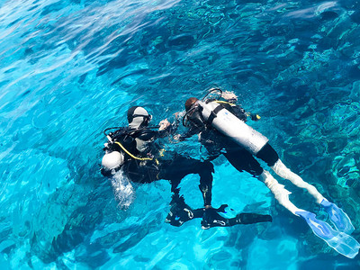 两名身着黑色水肺潜水服的潜水员背景图片