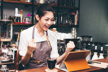 成功的女咖啡员在咖啡店图片