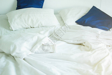 床上有白色枕头和深蓝色图片