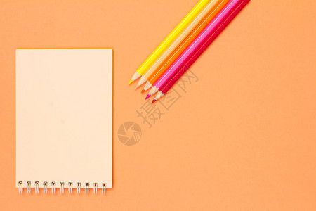 粉红色背景上的书剪刀笔记本彩色铅笔和指南针带有复制空间的顶视图回到学校的概念学校用品背景图片