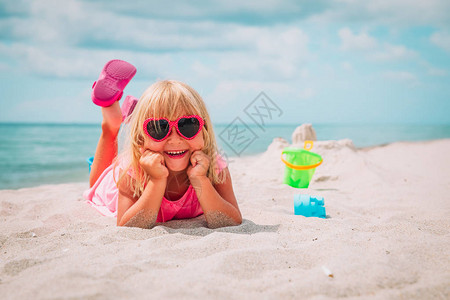 可爱的小女孩玩沙在海滩图片