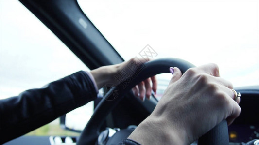 年轻的女商人司机在高速公路上开车库存特写年轻漂亮的女人在路上驾驶图片