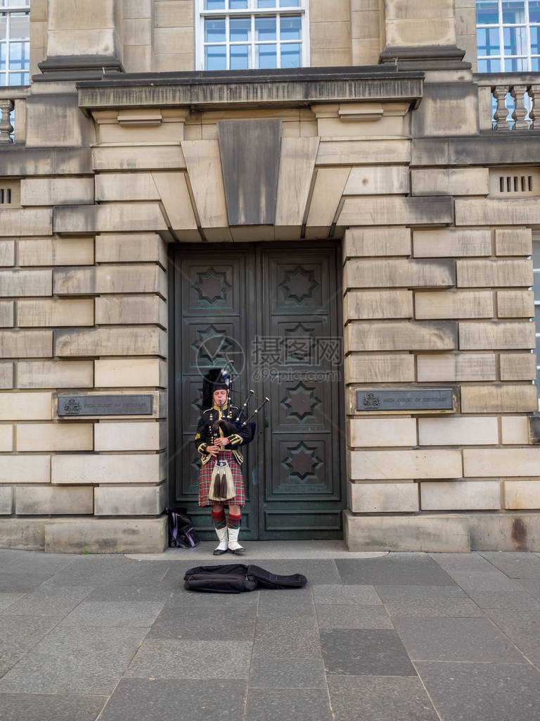 一名身穿传统苏格兰服装的苏格兰人在皇家大道上吹奏风笛图片