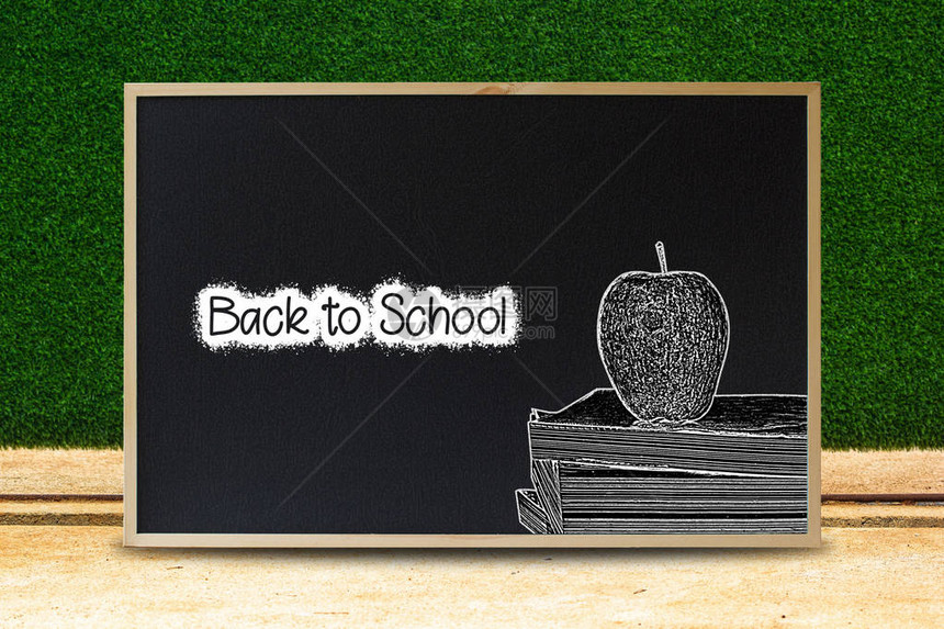 黑色到学校的概念黑色板纹理与文字和苹果堆叠书粉笔风格与绿色离开背景广告图片