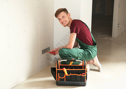 男电工在公寓里修理插座图片