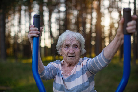 老年妇女在街头运动操场上做晨锻活动图片