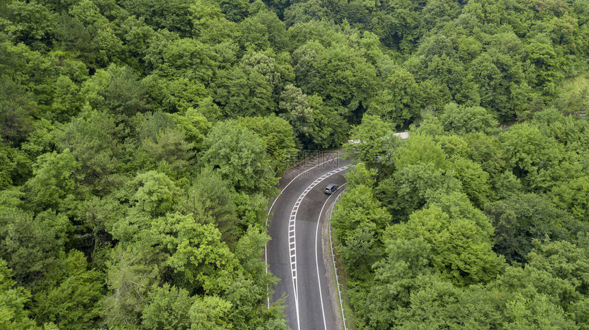 汽车沿着蜿蜒的山口公路穿过俄罗斯索契森林的空中库存照片图片