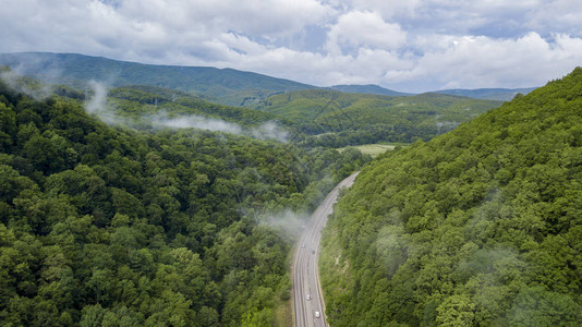 汽车沿着蜿蜒的山口公路穿过俄罗斯索契的空中库存照片背景图片