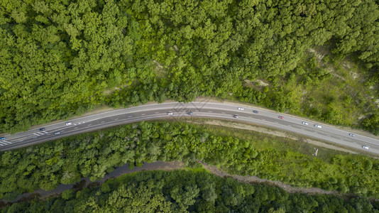 汽车沿着蜿蜒的山口公路穿过俄罗斯索契森林的空中库存照片背景图片