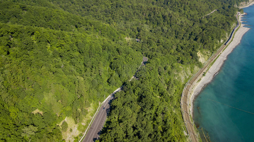 汽车沿着蜿蜒的山口公路穿过俄罗斯索契森林的空中库存照片图片