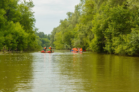 一群身穿救生衣的人乘坐充气双体船漂浮在河上图片