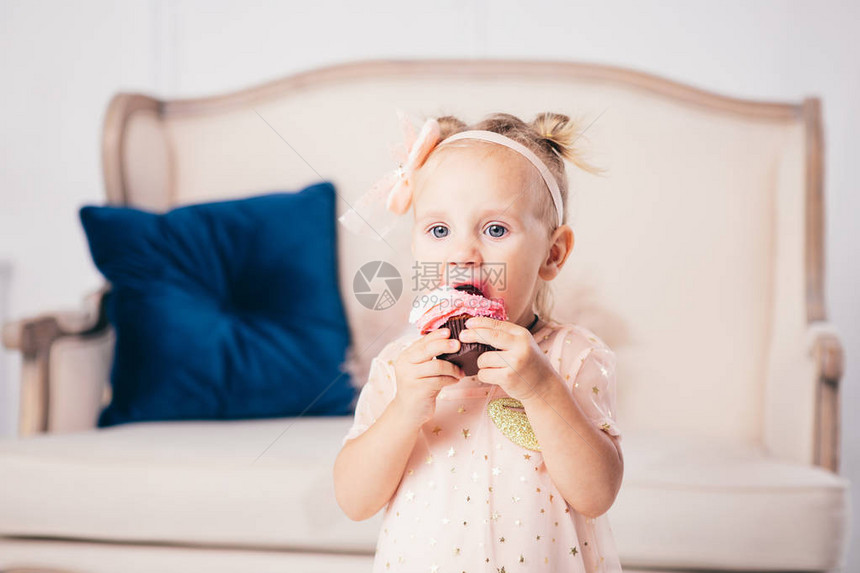 穿着粉红色连衣裙的有趣的两岁白人女孩站在房子的卧室里图片